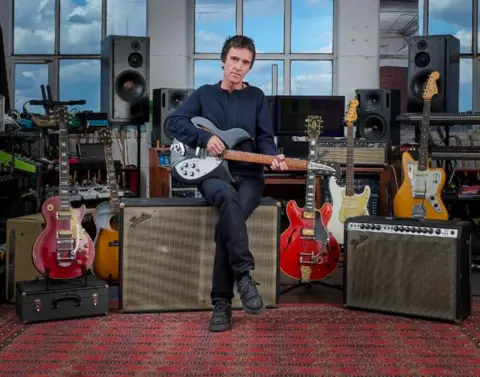 Christie's Johnny Marr poses with a series of guitars and amps