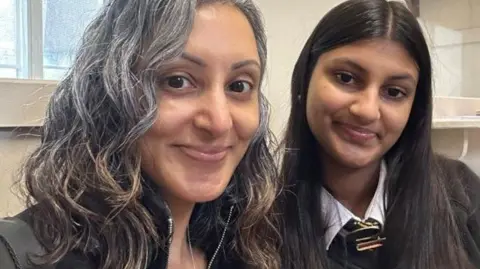 Sharan Uppal Sharan (pictured on the left) sits with her daughter Simran. Simran is 15 and is wearing her school uniform. 