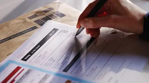 Woman filling in postal vote form