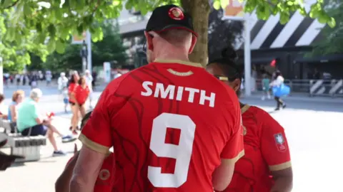 Jack Vaply/BBC A man who has a red white white Town FC shirt with "Smith 9" on the back.