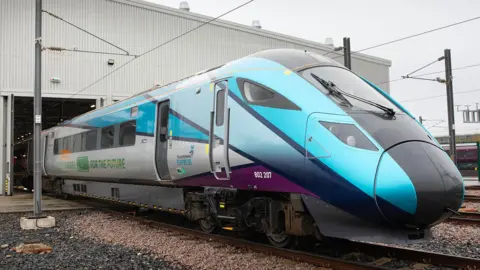 Hitachi Rail Hitachi Rail's test tri-mode train on the tracks as it leaves the company's factory in Newton Aycliffe in England. On the side the words "fully charged for the future" are written.