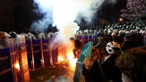 Petugas polisi Riot Reuters berdiri dalam formasi di sebelah demonstran selama protes terhadap penahanan Walikota Istanbul Ekrem Imamoglu di Istanbul.