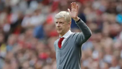 Arsene Wenger waves to the Arsenal fans from the touchline during his spell as manager