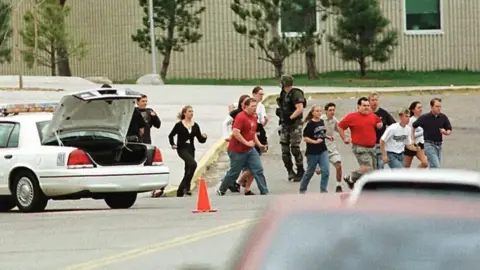 Mark Leffingwell/AFP/Getty Images School pupils and staff are seen running from the school with an armed soldier