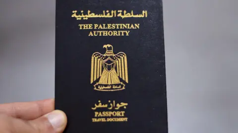 Getty Images File image of a hand holding a passport issued by the Palestinian Authority