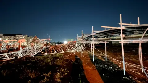 A view of a fallen helicopter tower, which lies broken on the ground in Houston at night.