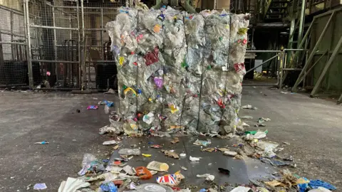 A pile of recyclable materials tied together in a large square-shaped block.