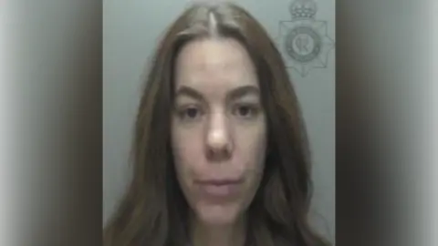 Humberside Police A police custody shot of Manuela Metaj. She has long, brown hair and is standing in front of a grey wall, looking at the camera.