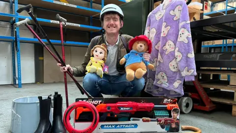 Nexus Metro marketing officer poses with some of the objects lost on the Metro in 2023