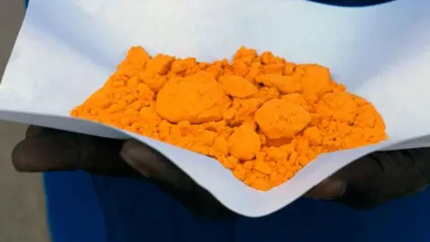 Getty Images A man holds "yellow cake" in a uranium mine in Niger