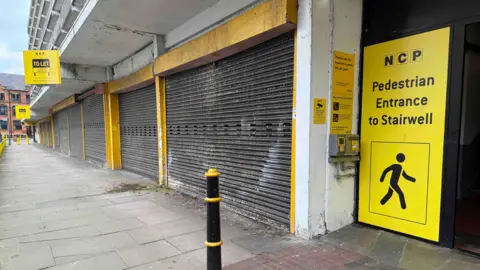 Looking along the business units which are shuttered up below Lee Circle car park
