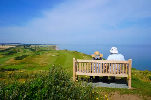 Sally Esau A couple on a bench overlooking the sea