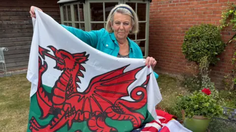 Sue Wiles, 82, who is known at the flag lady in village of Stapleford, where she lives, shows her Welsh flag, one of about 20 that she owns