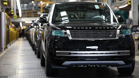 Getty Images A line of Range Rovers on a production line in a UK factory