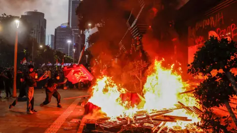 EPA Protesters are seen placing road barriers onto a fire outside a police headquarters in Jakarta
