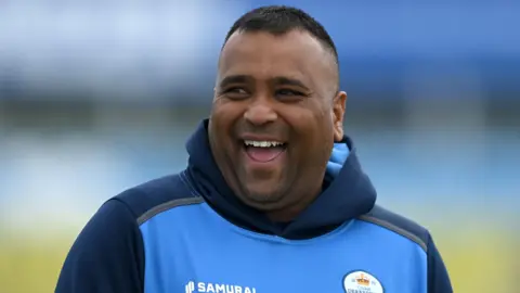Samit Patel laughs while warming up for Derbyshire