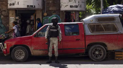 Reuters A member of the National Guard stands guard in the street after the killing of Alejandro Arcos, who had just taken office as the mayor of Chilpancingo, the capital of Mexico's state of Guerrero, on 11 October 2024