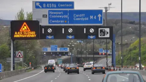 A motorway in Newport with blue signs indicating that drivers should be in the left hand lane for Newport and Cwmbran, and the right two lanes for Cardiff.