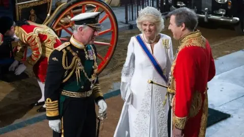 Getty Images Britain's Prince Charles, Prince of Wales (L) and his wife Camilla, Duchess of Cornwall (C) are met by Edward Fitzalan-Howard, Duke of Norfolk (R), as they arrive for the State Opening of Parliament at the Palace of Westminster in central London on May 27, 2015.