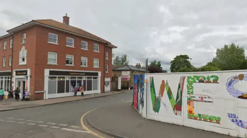Google Junction of West St Rochford, showing a Sainsbury's Local supermarket and part of a giant West St sign