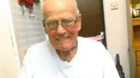 Picture of Tommy Ward: an elderly man wearing a white shirt and glasses