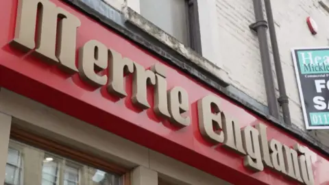 Sign saying Merrie England on a shopfront