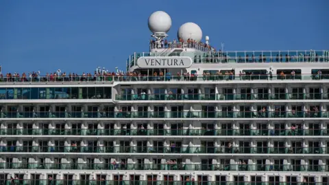 Getty Images Passengers stand on deck next to Ventura sign