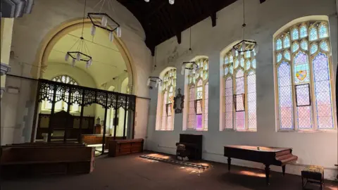 Thetford Town Council The interior of St Peter's Church, showing the altar and side windows, and a baby grand piano 