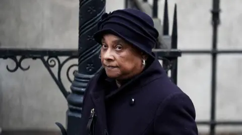 PA Baroness Lawrence in purple hat and coat
