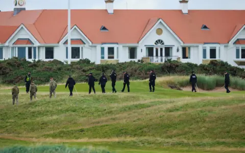 Reuters A line of military personnel and police sweep a stretch of grass outside the luxury Turnberry resort