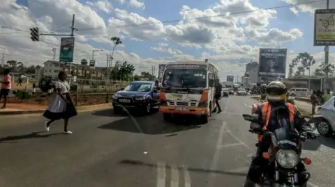 AFP Buses, motorbikes and pedestrians use Ngong Road in Nairobi, in 2022.