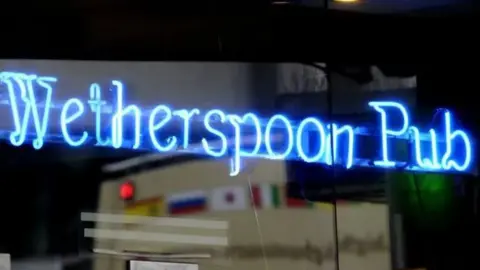 A close up of a blue neon JD Wetherspoon pub sign