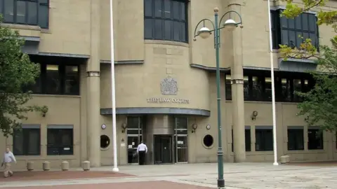 PA The front of Bradford Crown Court: a beige building with windows to the side and above the entrance. A lamp-post is in the foreground.