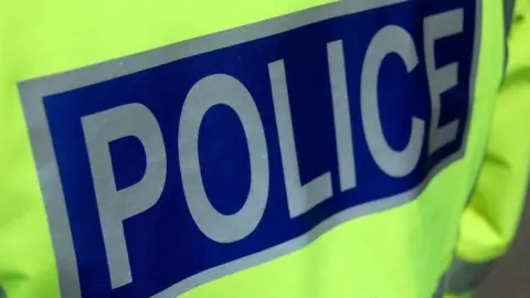 BBC Police jacket with the word "police" in silver wording on a blue background.