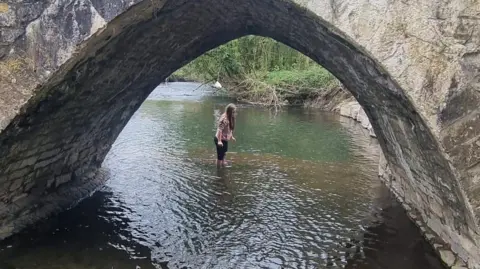 Melanie Hill Evie in the River Ogmore under a bridge 
