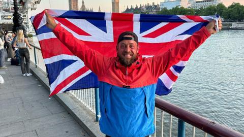 Paul Harris in central London holding a Union Jack aloft 