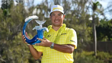 Hideki Matsuyama holding The Sentry trophy in 2025