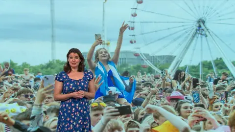 Gillian Smart stands in front of an image of TRNSMT music festival