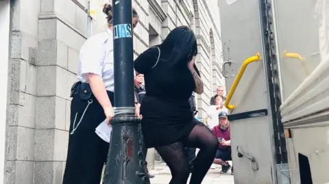 Courtney Gartshore, dressed in black, is led away from the High Court in Aberdeen.