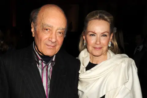 Dave M Benett/Getty Images Mohammed Al Fayed and Heini Wathen-Fayed stand outside a building, dressed smartly.