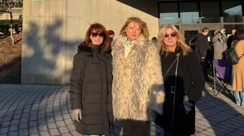 Ellen Munoz (right), Peggy Gould (centre) and Debra Timms outside court