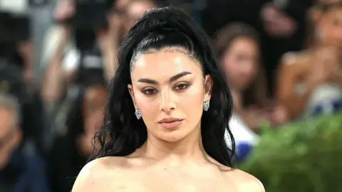 Getty Images A picture of Charlie XCX at the Met Gala in New York. Her black hair is tied up.