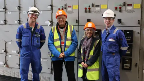 EDF Four people stand in front of controls at Hinkley Point B power station in Somerset where they've all worked. 