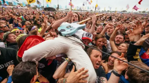 A guitarist from the Idles in the crowd while playing the Other Stage during the Glastonbury Festival at Worthy Farm in Somerset