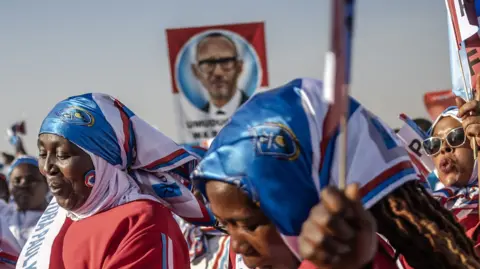 AFP Rwandan Patriotic Front (RPF) supporters wave party flags while dancing to songs in support of Incumbent President of Rwanda and presidential candidate Paul Kagame during a campaign rally in Kigali, on July 13, 2024