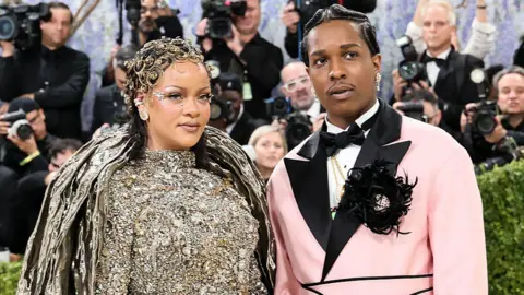 Theo Wargo/FilmMagic Rihanna and ASAP Rocky on the red carpet of the Met Gala. There are many photographers behind them