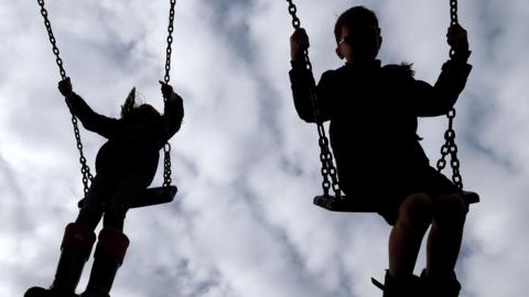 Image of children playing on a swing