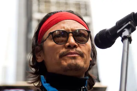 Getty Images Tenzin Tsundue joins Amnesty International for the United States of America, journalists without borders and the 100th Committee for a peaceful protest in favor of freedom in Tibette in Times Square on March 9, 2012 in New York City. He is photographed with sunglasses and redna red.