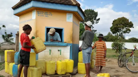 Reuters People amid yellow sheets in a water vendor's hut in Madagascar.
