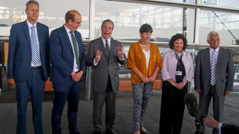 Getty Images Nathan Gill, Mark Reckless, Nigel Farage, Mandy Jones, Caroline Jones and David Rowlands stand next to each other outside the Senedd.